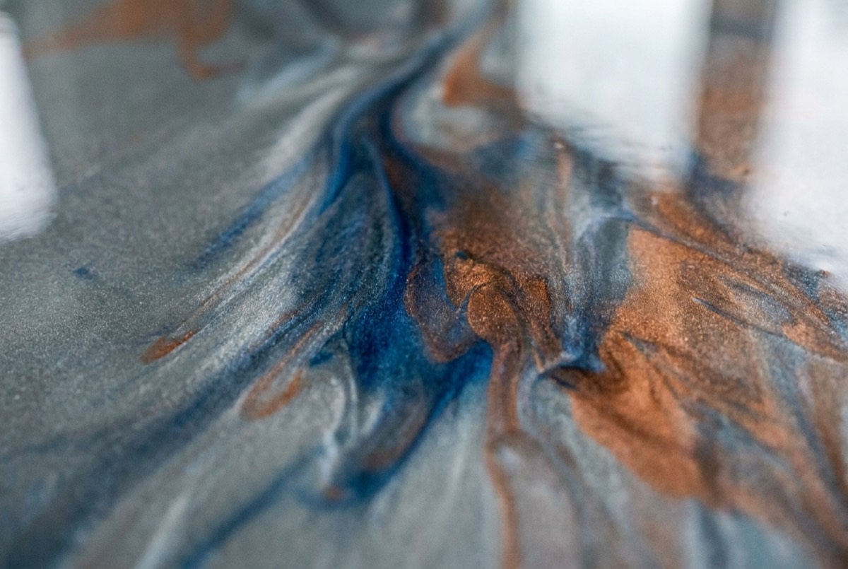 Illustration of a close-up of a metallic epoxy floor with swirling gray, blue, and copper pigments